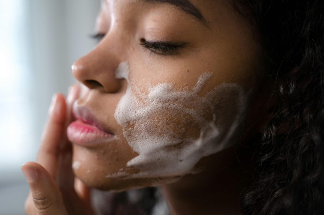 Woman cleansing her face with foam